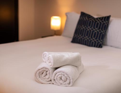 a pile of towels sitting on top of a bed at Oasis studio in the Heart of the City in Brighton & Hove