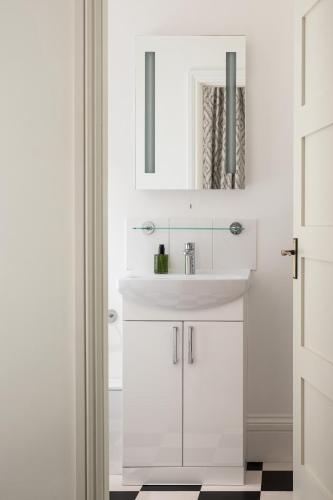 a white bathroom with a sink and a mirror at Brayford House Carholme Road - Serviced Accommodation in Lincoln for Contractors, Business & Leisure Stays in Lincoln