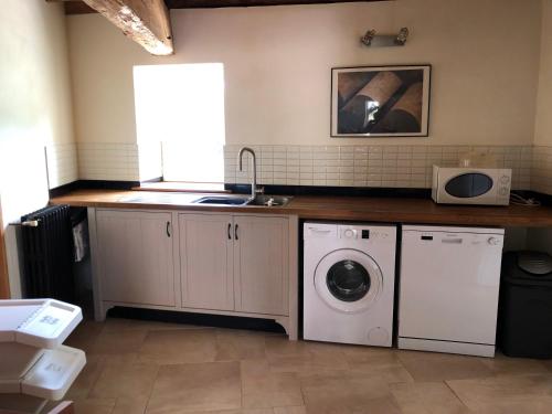 une cuisine avec un évier et une machine à laver dans l'établissement La Maison du Lac****, à Saint-Martin-de-Gurçon
