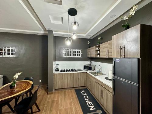 a kitchen with a table and a refrigerator at The loft/lilysvilla in Agbédinou