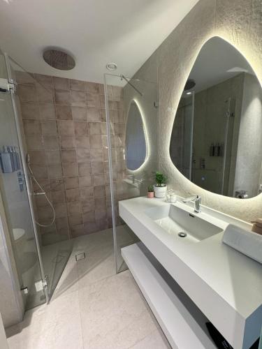 a bathroom with a sink and a mirror at Allenbeach TLV- apart Hotel- Adults only in Tel Aviv