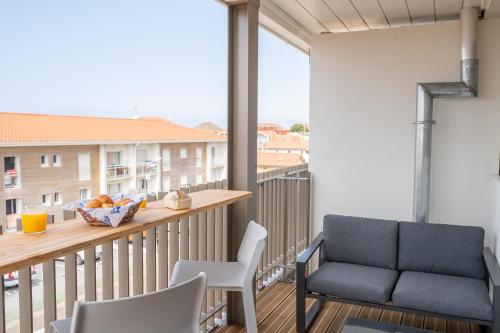 a balcony with a couch and a table and chairs at Résidence Lou Cout in Vieux-Boucau-les-Bains