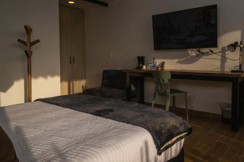 a bedroom with a bed and a desk and a television at Alto Bonito Campestre in Circasia
