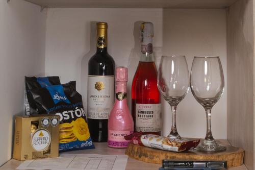 a shelf with two wine bottles and two wine glasses at Alto Bonito Campestre in Circasia