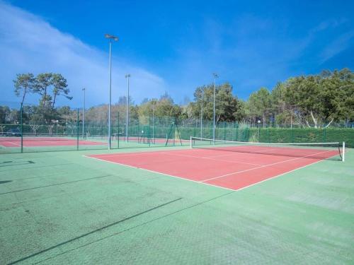a tennis court with two tennis nets on it at Villa ROMA in Soustons