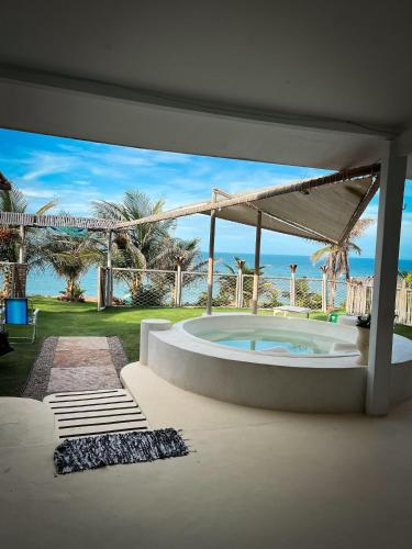 a room with a hot tub with a view of the ocean at ASAS DEL MAR - SUITES in Canoa Quebrada