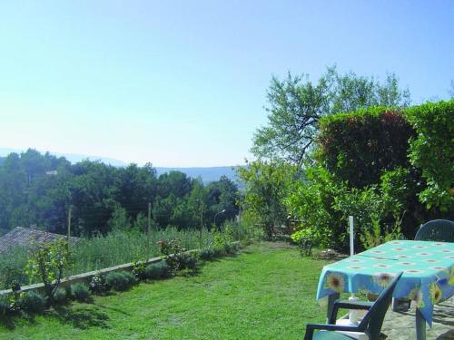 einen Tisch und Stühle in einem Garten mit Aussicht in der Unterkunft Gîte Le Val des Fées classés deux étoiles in Roussillon