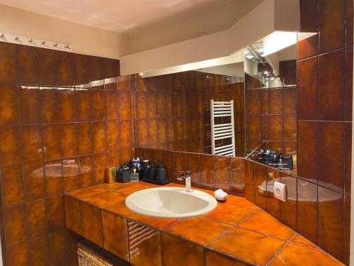 La salle de bains est pourvue d'un lavabo et d'un miroir. dans l'établissement Villa Galateias, un coin de Paradis, superbe vue avec piscine, à Cannes