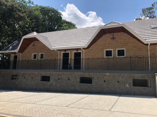 a brick house with a metal roof at La Floresta Suites in Campos do Jordão
