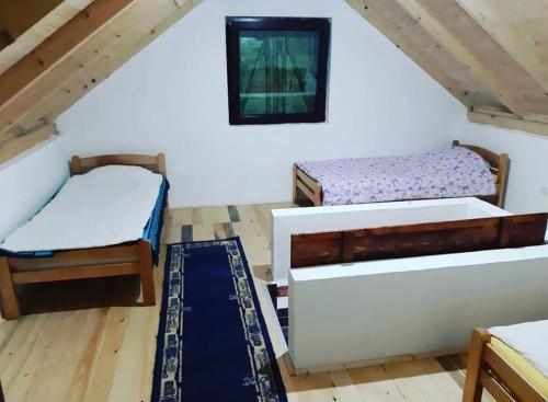 a room with two beds and a rug at Veskov Konak in Andrijevica
