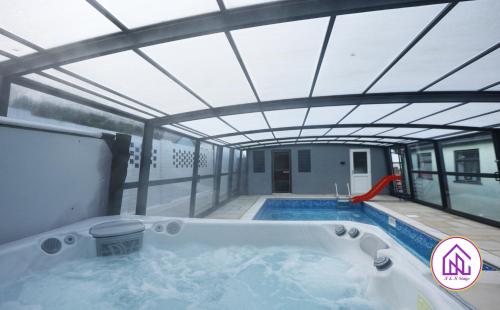 a hot tub in a building with a roof at Luxury House, Swimming Pool, Hot Tub, Sauna in Cardiff