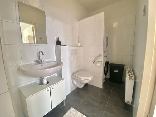 a white bathroom with a sink and a toilet at Monumental independent Studio, City Centre Dordrecht in Dordrecht