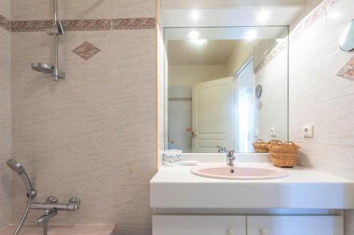 een badkamer met een wastafel en een spiegel bij Appartement jardin d'emilie in Saint-Raphaël