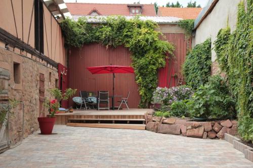une terrasse avec un banc et un parasol dans l'établissement HOPLA, à Hurtigheim
