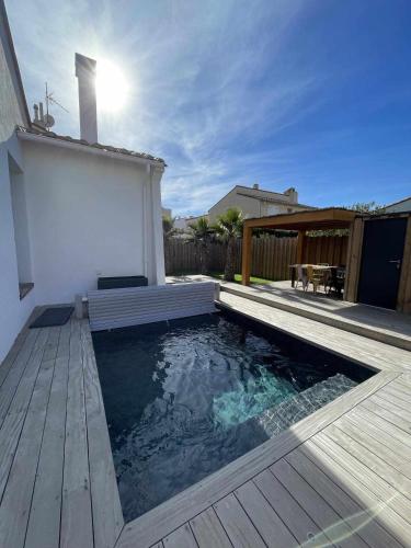 une piscine avec une terrasse en bois et une maison dans l'établissement Saint Cyprien villa avec piscine privée, à Saint-Cyprien