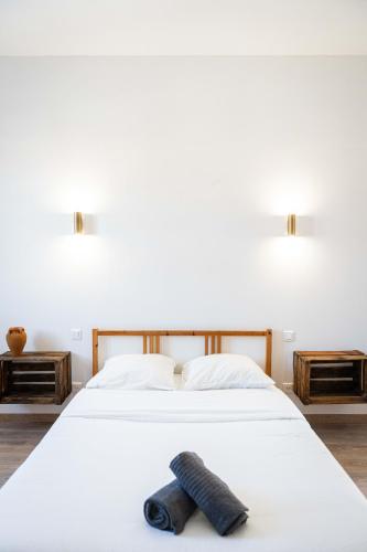 a bedroom with a white bed with a black object on it at Grand appartement Familiale - Camargue in Salin-de-Giraud