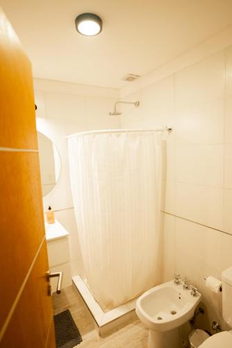 a white bathroom with a toilet and a sink at Sucre Suites in Buenos Aires