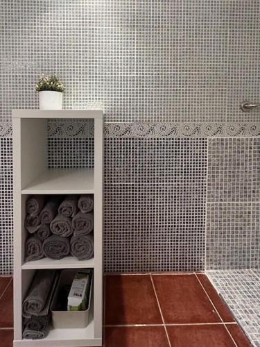 a white shelf in a bathroom with a tile wall at Casa Chus, cerca de la playa in Los Pocillos