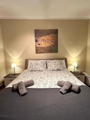 a bedroom with a bed with two pairs of slippers on it at Casa Chus, cerca de la playa in Los Pocillos