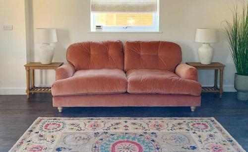 a brown leather couch in a living room with two tables at Linwood in Lincoln