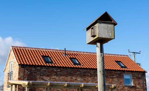 a bird house on a pole in front of a brick building at Linwood in Lincoln