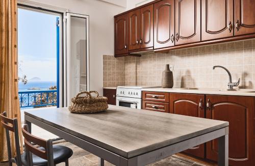 a kitchen with a table and a view of the ocean at Tramontana Suites in Áyios Stéfanos