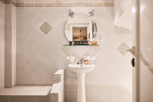 a bathroom with a sink and a mirror at Tramontana Suites in Áyios Stéfanos