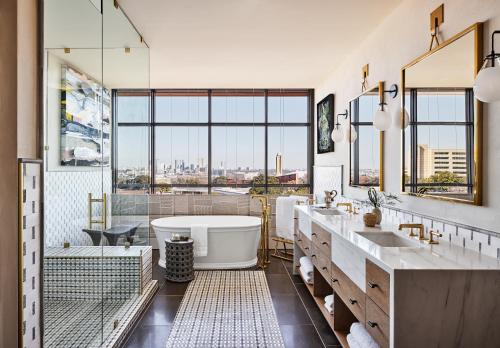 a bathroom with a tub and a large window at Bowie House, Auberge Resorts Collection in Fort Worth