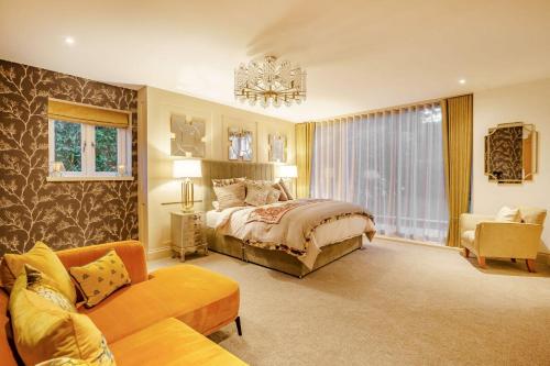 a large bedroom with a bed and a couch at Skyfall in Prestbury