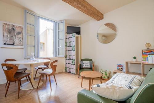 a living room with a couch and a table and chairs at Le petit Saint Jean T2, Clim, Centre historique in Montpellier