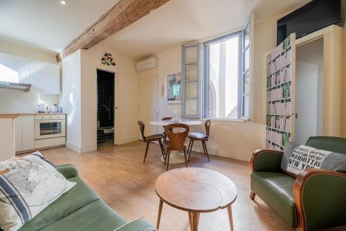 a living room with a couch and a table at Le petit Saint Jean T2, Clim, Centre historique in Montpellier