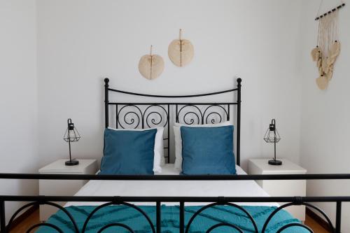 1 dormitorio con 1 cama con almohadas azules en *Private Outdoor Area* 300m-Beach, Swing/No Stairs, en São Martinho do Porto