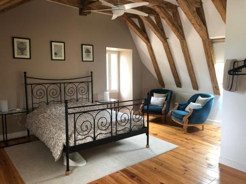 - une chambre avec un lit, deux chaises et un ventilateur de plafond dans l'établissement La Maison du Lac****, à Saint-Martin-de-Gurçon