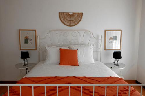 1 dormitorio con cama blanca y almohada naranja en *Private Outdoor Area* 300m-Beach, Swing/No Stairs, en São Martinho do Porto