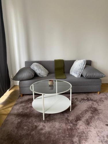 a living room with a couch and a glass table at Comfort appartment in Värnhem, Malmö in Malmö