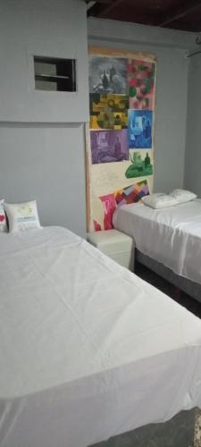 um quarto com duas camas e um quadro na parede em Hostel Dakini em Lomas de Zamora