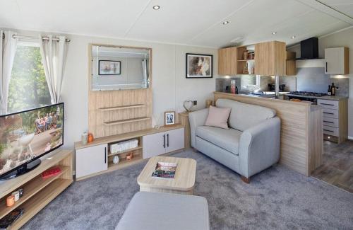 a living room with a couch and a tv at Seaton Estate in Arbroath
