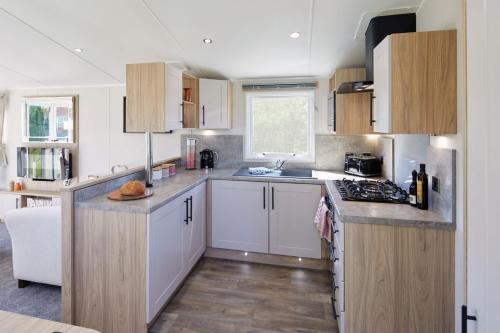 a kitchen with white cabinets and a counter top at Seaton Estate in Arbroath