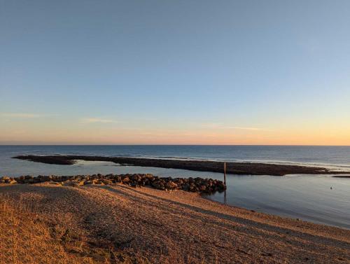 a beach with a bunch of rocks in the water at Swift Mosselle Pitch 24 Creek Caravan Park dog friendly in Ringstead