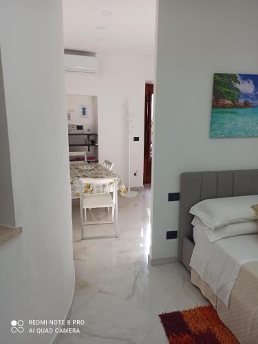 um quarto branco com uma cama e uma mesa em MEDUSA house em Taormina