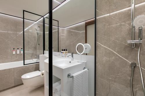 La salle de bains est pourvue d'un lavabo, de toilettes et d'une douche. dans l'établissement Labtwentytwo Barcelona, a Tribute Portfolio Hotel, à Barcelone