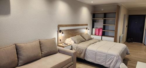 1 dormitorio con 1 cama y 1 sofá en Quequen - Casa Las Olas en Quequén