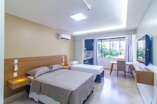um quarto com 2 camas, uma secretária e uma janela em GARVEY FLAT em Brasília