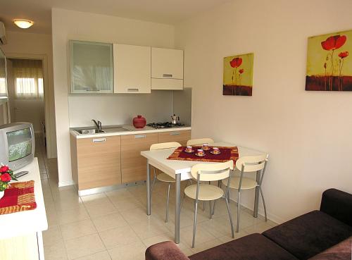 a kitchen with a table and chairs in a room at Appartamenti Ai Pini in Bibione