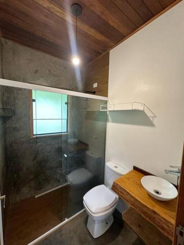 een badkamer met een douche, een toilet en een wastafel bij Casa @nomeiodanatureza com piscina e cachoeira in São Francisco Xavier