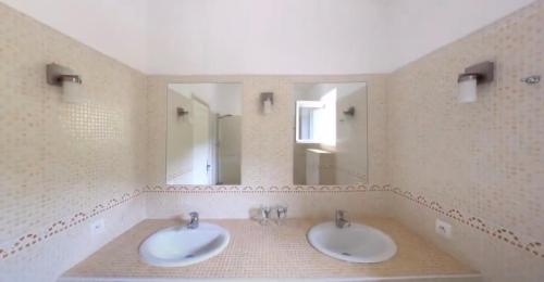 dois lavatórios numa casa de banho com dois espelhos em Villa Fleury Appartement em Montbrun-les-Bains