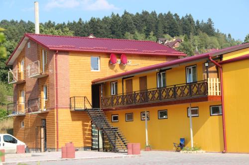 ein großes gelbes Gebäude mit einer Treppe drauf in der Unterkunft Villa Leontiya in Schidnyzja