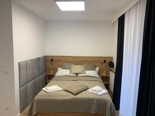 a bedroom with a large bed with a wooden headboard at Apartament Cicha 16B2 in Krynica Zdrój