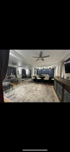 a living room with a ceiling fan and tables at Sugarbird Villa in Black Rock