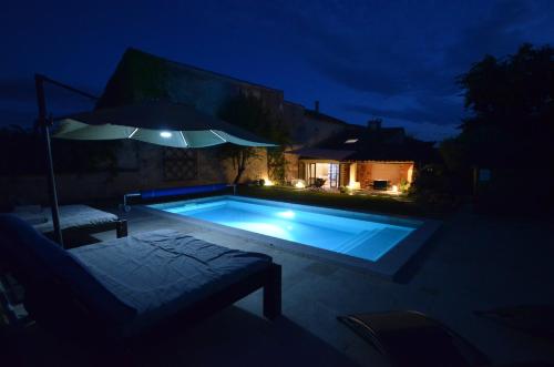 - une piscine avec parasol la nuit dans l'établissement La maison d'Anthonie, Roussillon, à Roussillon
